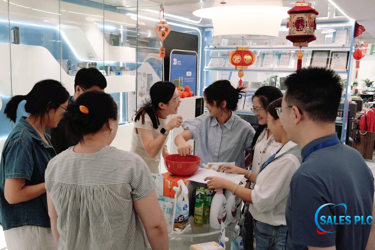 Colleagues gather around a red bowl during a Mid-Autumn Bo Bing activity